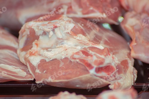 Preview: Raw cuts of meat, laid out on a black surface