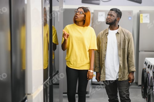 Preview: African american family couple buying domestic refrigerator in supermarket