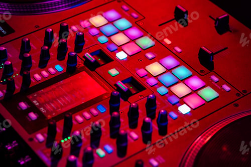 Preview: Close up of DJ mixing console in party light