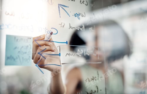 Preview: Cropped shot of an unrecognizable young businesswoman working on a glass wipe board in her office