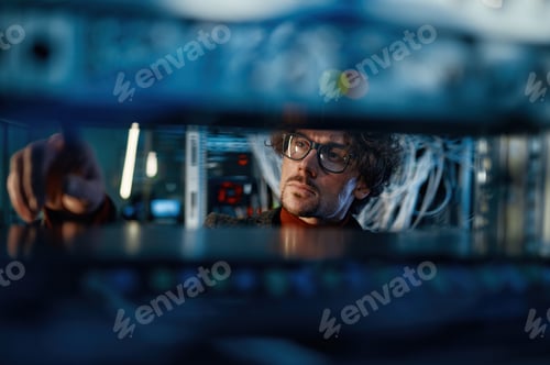 Preview: Male IT professional working in server room selective focus