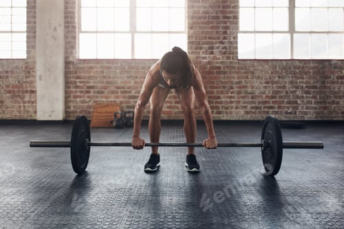 Preview: Fit young woman working out with a barbell