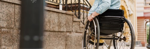 Preview: Brunette woman sitting in wheelchair on city street