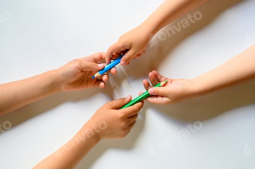 Preview: kid's hands share each other colored pencils on a white background