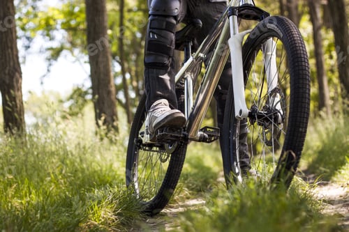 Preview: Selective focus shot of a male riding a bike in the nature