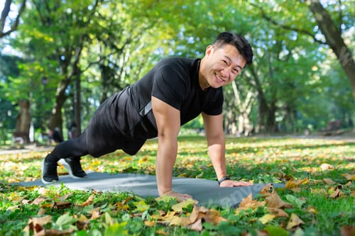 Preview: Portrait of happy male athlete, Asian looking at camera and smiling doing physical exercises, push
