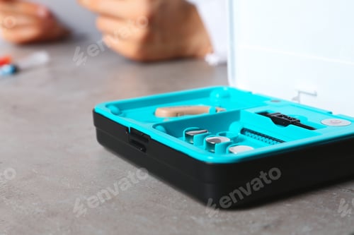 Preview: Hearing aid kit on table, closeup with space for text