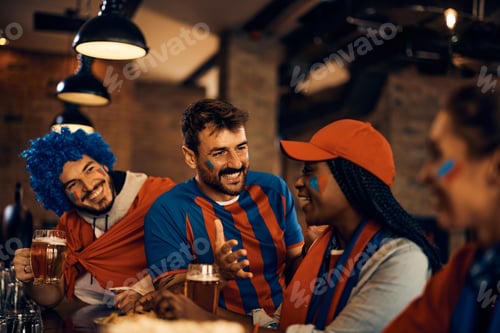 Preview: Happy sports fans having fun while gathering in pub during the world cup.