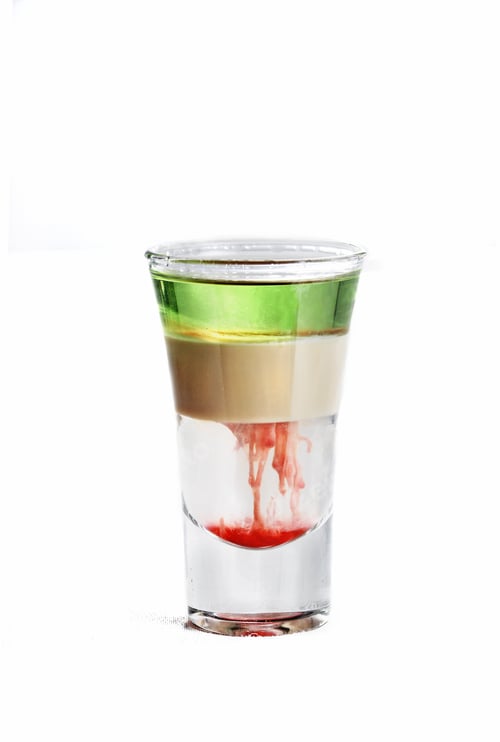 Preview: Vertical isolated shot of a multi-colored cocktail in a vodka glass - perfect for menu usage
