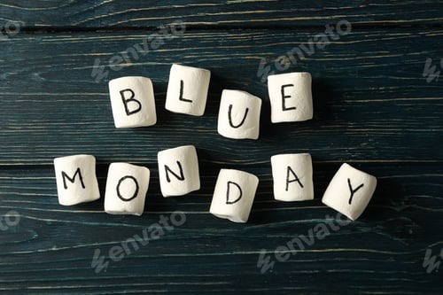 Preview: Marshmallows with text Blue Monday on dark blue wooden background, top view