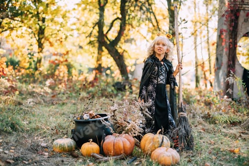 Preview: Beautiful girl witch. little girl in which costume celebrate Halloween outdoor and have fun