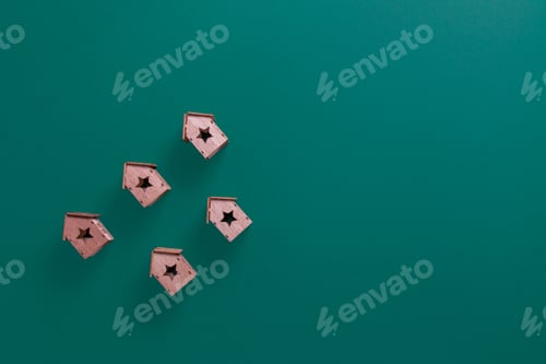 Preview: Top view of small wooden houses as Christmas ornaments on a green surface