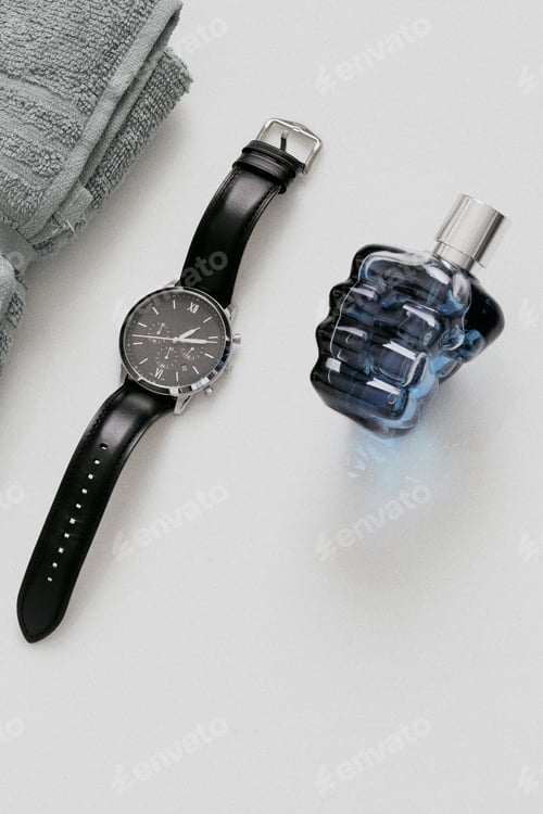 Preview: Vertical top view of a male watch, perfume, and towel - groom wedding preparation concept