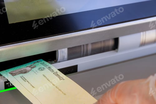 Preview: Hand of a woman with deposit stimulus check in banking using an ATM
