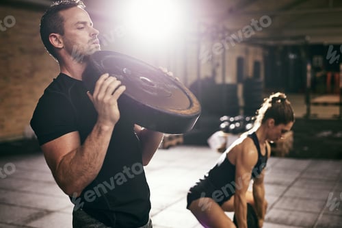 Preview: Young sportsmen having workout with weight disks