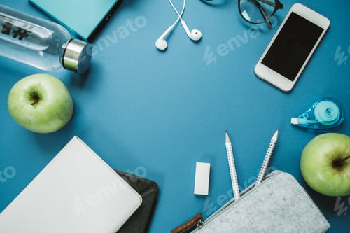 Preview: Modern Work space for healthy person: pencils, water, apple, phone, glasses, headphones