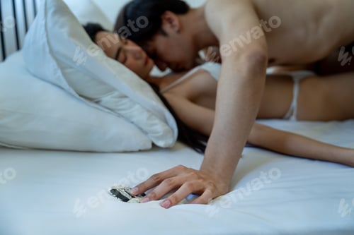 Preview: Close up hand of Asian man touch condom on bed during has sexual activity with couple woman on bed.