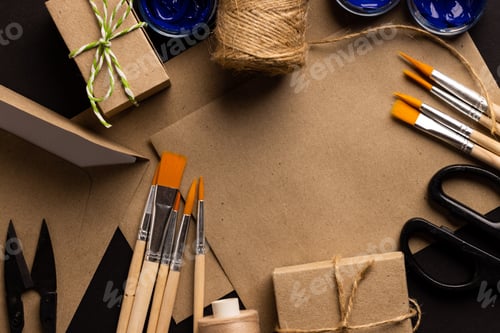 Preview: Image of close up of scissors, paint brushes and threads and copy space on cream background