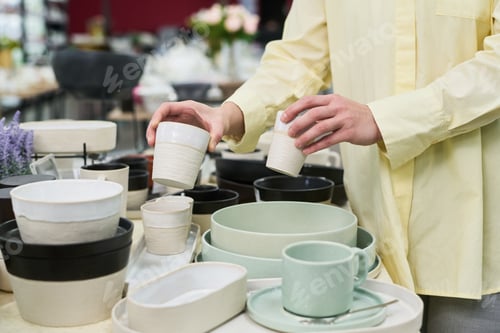 Preview: Unknown Woman Arranging Ceramic Tableware in Store Display