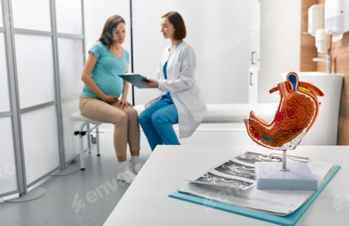 Preview: Pregnant woman with heaviness in stomach at appointment with gastroenterologist. Stomach problems,