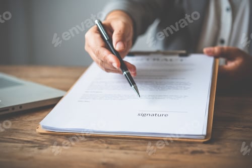Preview: Signing a Contract Document on a Wooden Table