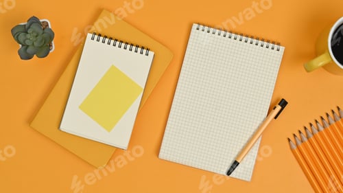 Preview: Top view of blank notepads, sticky note, pencils and coffee cup on yellow background.