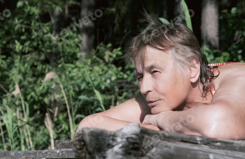 Preview: A woman of 70 years old lies on the beach and sunbathes
