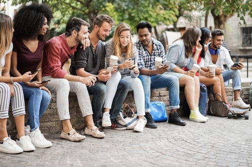 Preview: Group of friends using mobile phones outdoors in city park - Main focus on african girl face