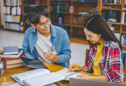 Preview: Students are consulting each other working on laptops and searching for books