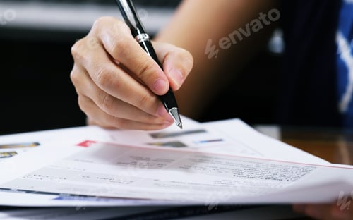 Preview: Working woman holding black pen for signing documents paper closeup on table background