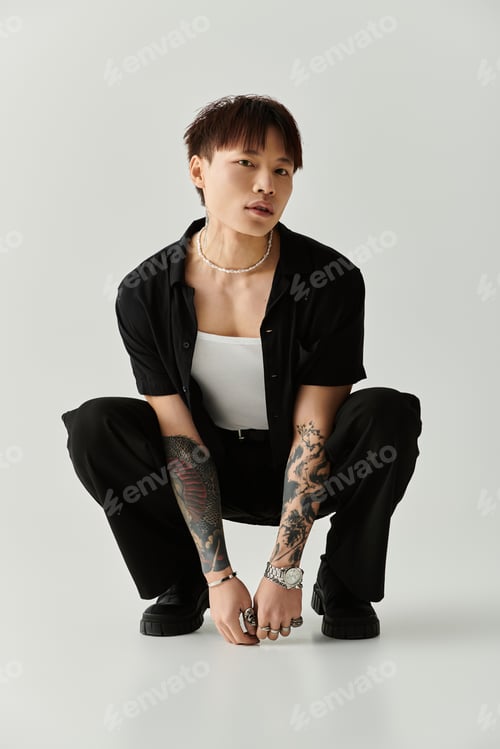 Preview: Stylish young Asian man poses confidently in a trendy indoor setting for a fashion showcase