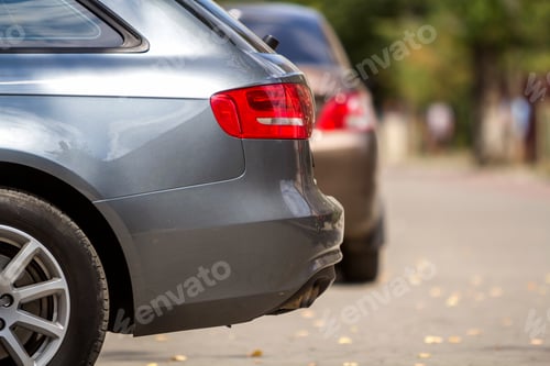 Preview: KYIV, UKRAINE - July 9, 2018-New shiny luxurious silver car parked on green trees bokeh background
