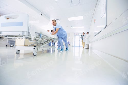 Preview: Medics urgently pushing hospital bed along corridor