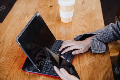 Preview: unrecognizable business woman working in digital tablet and mobile phone in office. technology