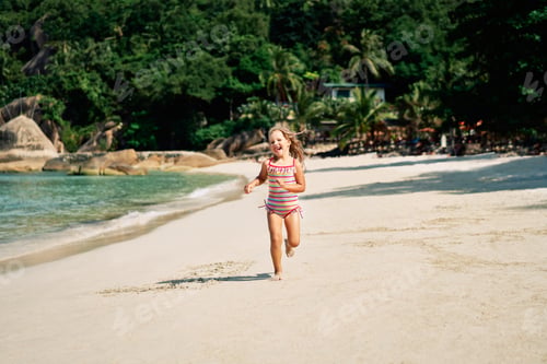 Preview: Pretty little girl running on ocean beach in tropical island