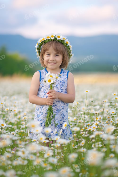 Preview: Cute little girl in big camomile meadow.