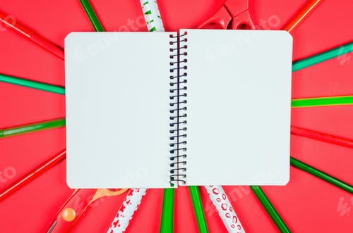 Preview: Red and green Colored different school supplies on red paper background.