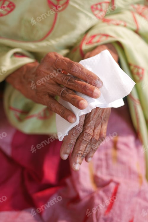 Preview: senior women disinfecting his hands with a wet wipe.
