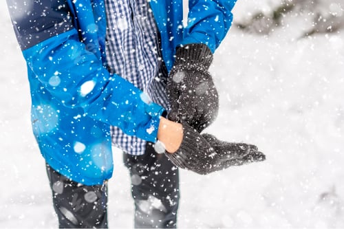Preview: man hands put on warm gloves on a winter cold day f