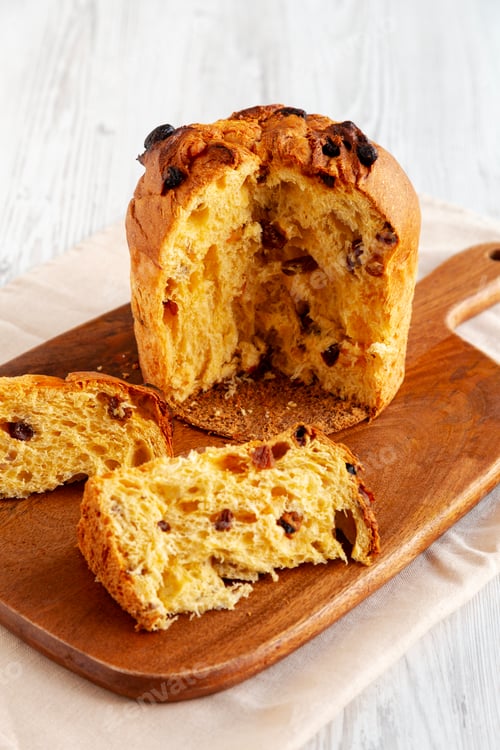 Preview: Homemade Christmas Eve Panettone Fruit Cake on a Wooden Board, side view.