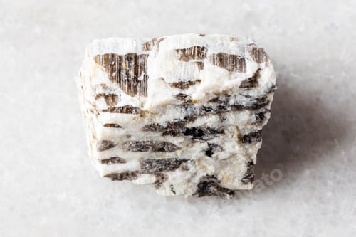 Preview: sample of raw written granite rock on white marble