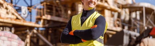 Preview: Cheerful man construction worker standing outdoors at industrial site