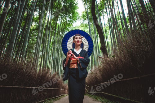 Preview: Beautiful japanese senior woman walking in the bamboo forest