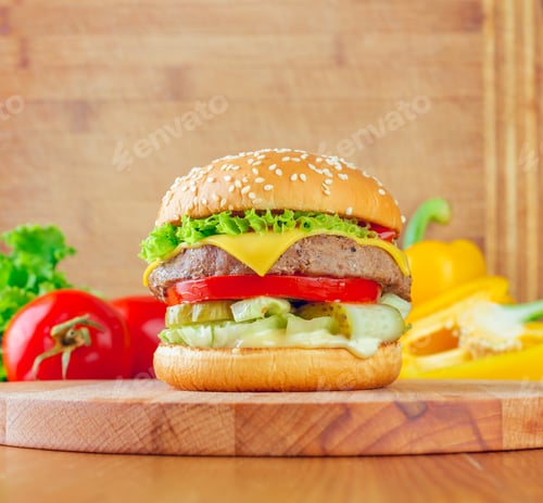 Preview: Delicious cheeseburger with fresh ingredients on a wooden table with colorful vegetables nearby