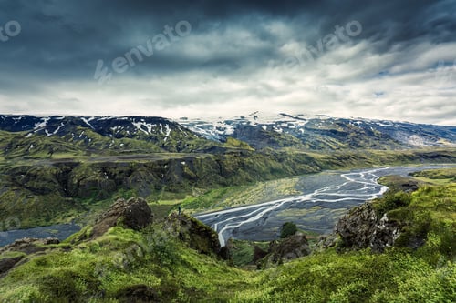 Preview: Volcanic landscape of Valahnukur trail and hiker woman standing in Thorsmork valley and moody sky
