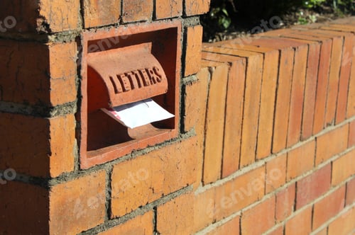 Preview: Old fashioned vintage antique terracotta letter box built into a brick wall