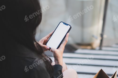 Preview: Young woman or teen girl hands holding smart phone with mockup white blank display