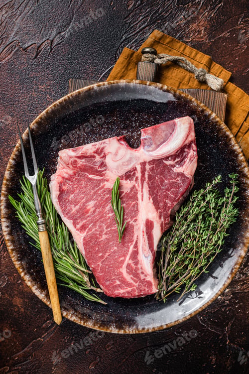 Preview: Dry aged Raw porterhouse beef meat Steak, fresh T bone on rustic plate with spice