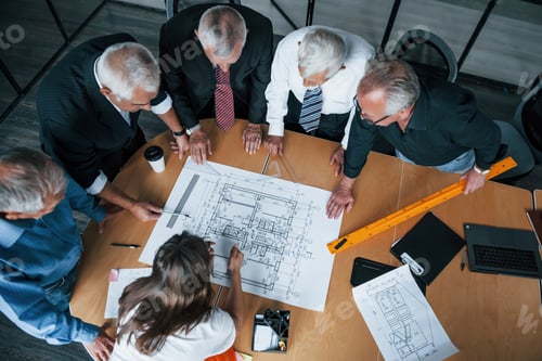 Preview: Aged team of elderly businessman architects have a meeting in the office with young woman and works