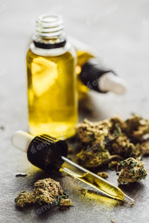 Preview: Selective Focus of Dropper With Hemp Oil, Medical Marijuana Buds And Bottles on Stone Surface